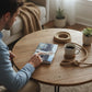 Mellow Monkey Basic Knot Book on a wooden coffee table with a man pointing at the cover and coiled rope nearby.
