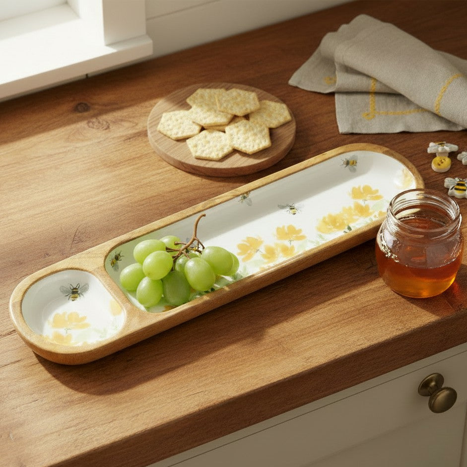 Mellow Monkey Bee Field sectioned mango wood tray with floral and bee pattern holding green grapes on a kitchen counter