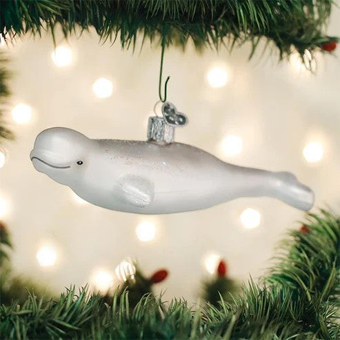 Mellow Monkey white blown glass beluga whale ornament with glitter accents, 5.5 inches, hanging on a Christmas tree.