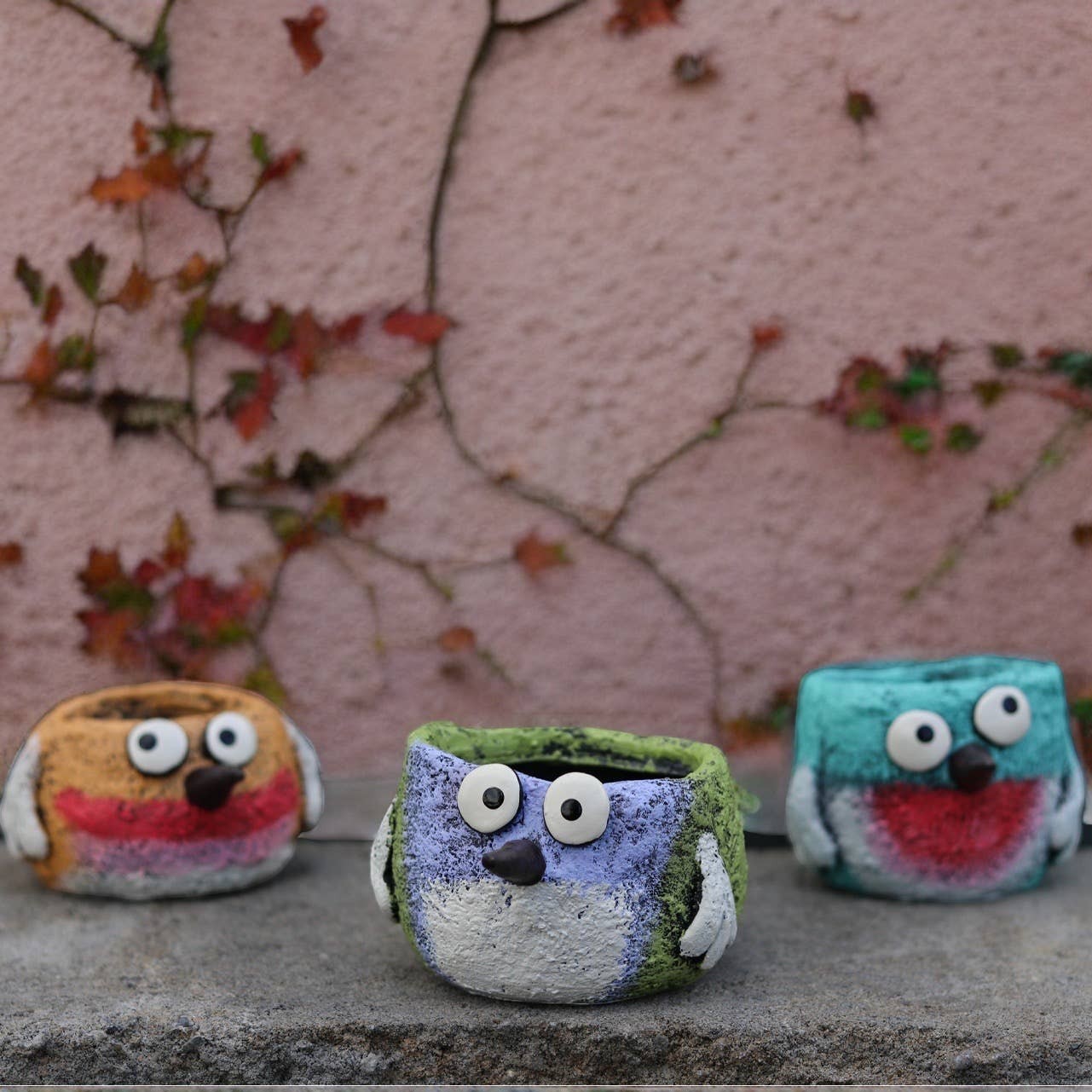 Mellow Monkey set of 3 whimsical poly-resin bird planters in yellow, periwinkle, and turquoise with hand-painted details.