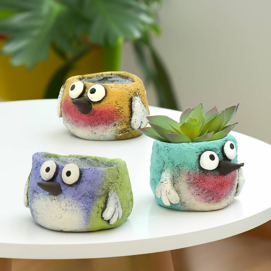 Mellow Monkey whimsical bird planters in yellow, periwinkle, and turquoise poly-resin. Handcrafted with expressive eyes and painted details.