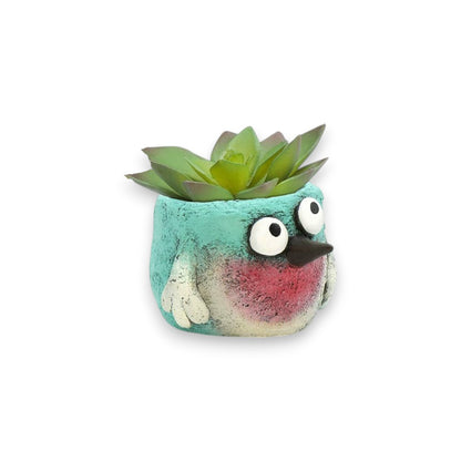 Mellow Monkey whimsical turquoise and pink poly-resin bird planter with googly eyes holding a succulent.