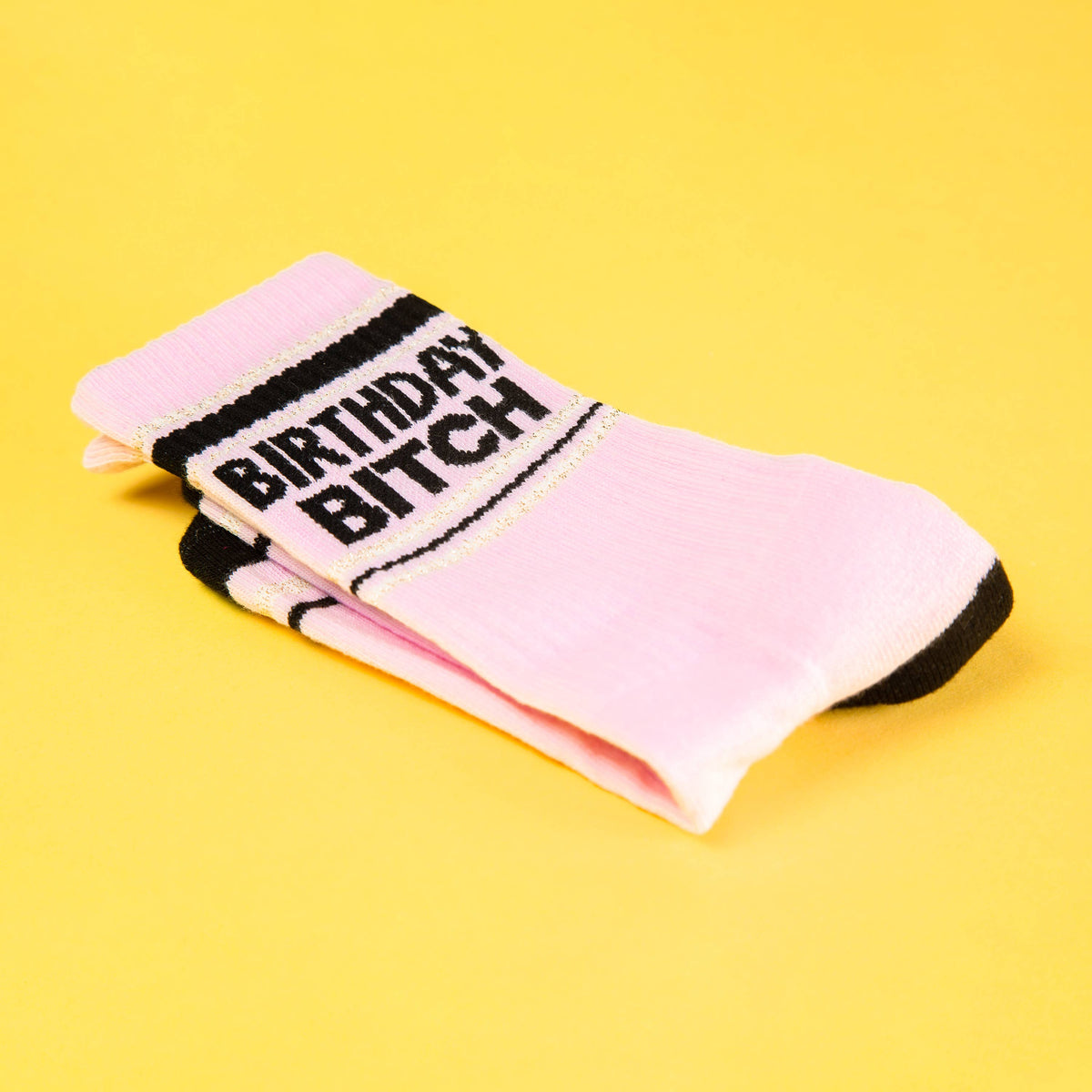 Mellow Monkey pink mid-calf gym crew socks with black Birthday Bitch text on a yellow background