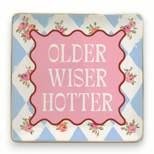 Mellow Monkey ceramic trinket tray with "Older Wiser Hotter" text, pink center, floral accents, and blue diamond pattern.