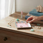 Mellow Monkey ceramic trinket tray with pink center, gold foil "Older Wiser Hotter" text, and floral border. Holds rings and jewelry.