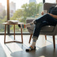 Mellow Monkey white crew socks with Bitch Please text and retro stripes worn by a man sitting in a chair.