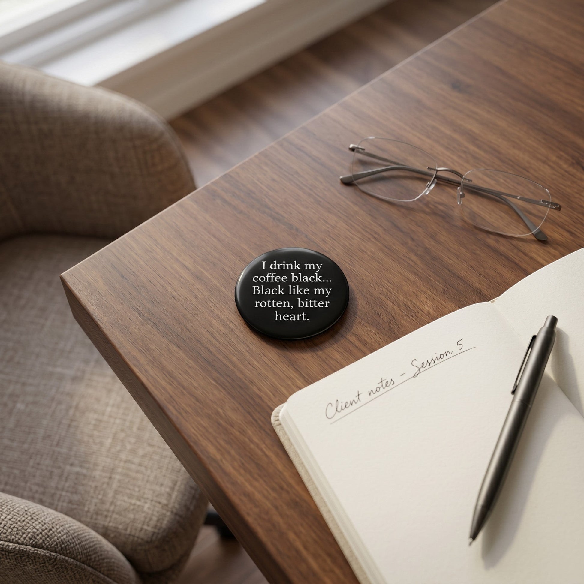 Mellow Monkey 1.25 inch round pin-back button with black background and white text on a wooden desk with a notebook.