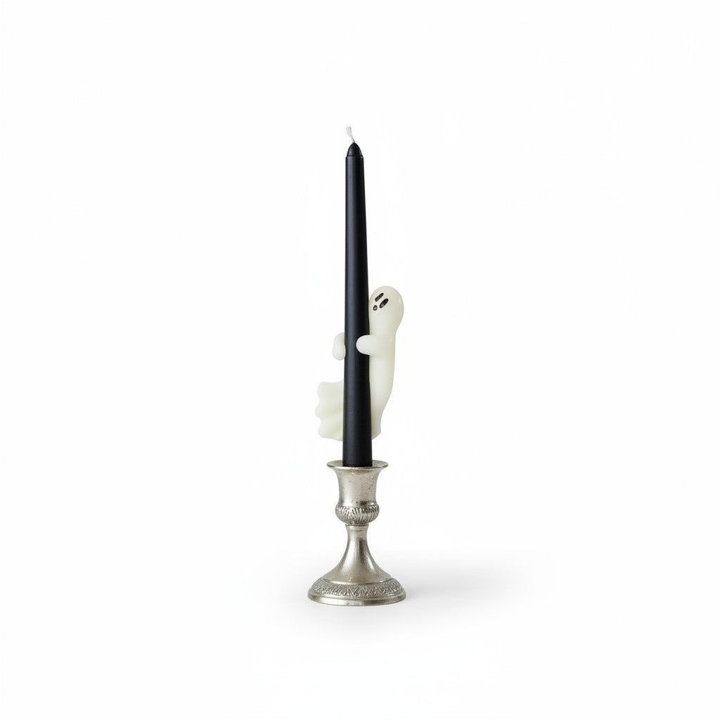 Mellow Monkey black unscented taper candle featuring a white ghost figure hugging the side, set in a silver holder.