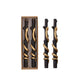 Mellow Monkey set of two unscented black twig-shaped taper candles featuring a decorative gold snake coiled around