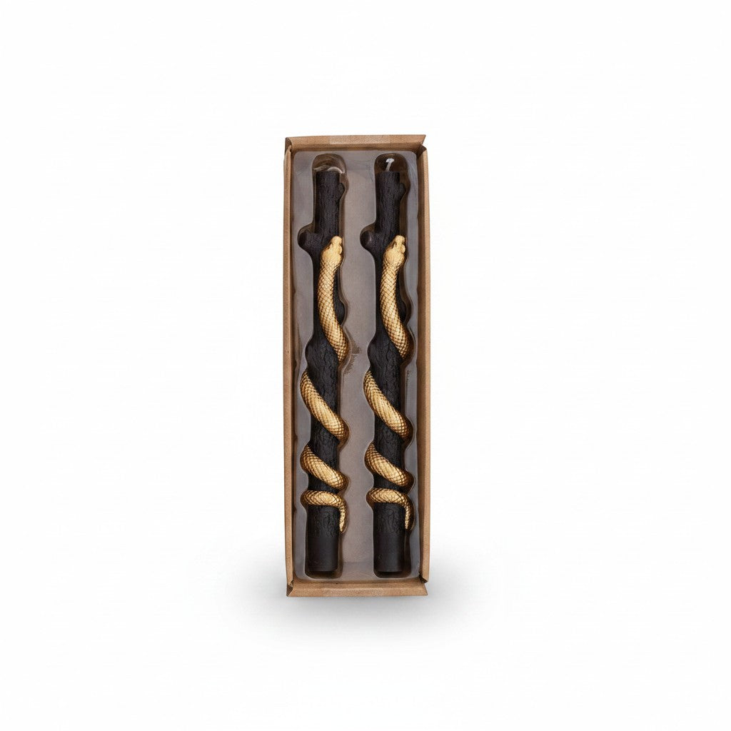 Mellow Monkey set of two black twig-shaped taper candles featuring a decorative gold snake coiled around each candle.