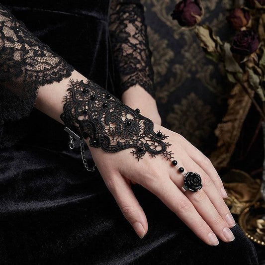 Mellow Monkey black lace fingerless ring-bracelet with a rose detail and bead accents on a model's hand.