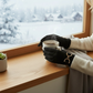 Mellow Monkey black microsuede gloves with gold bit detail and touchscreen fingertips held by a person with a mug.