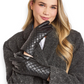 Mellow Monkey black quilted vegan leather gloves with stud detailing worn by a smiling woman in a grey coat