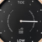 Mellow Monkey 12-inch black tide clock with a natural beech wood frame, white hands, and mineral glass face. Displays hours until high or low tide.
