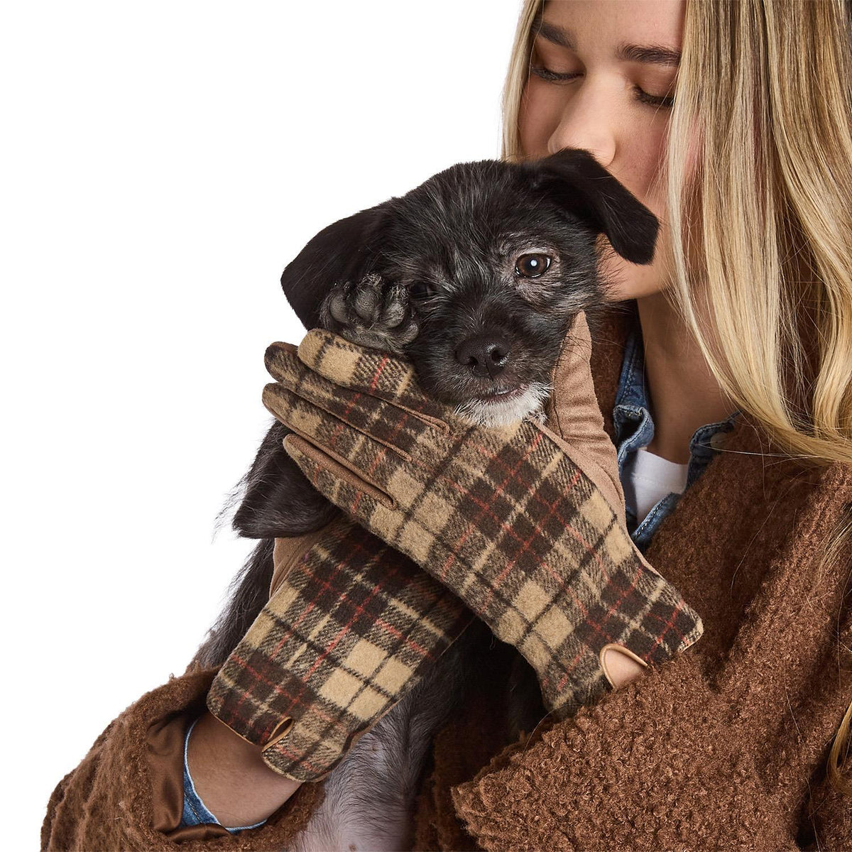 Mellow Monkey Blair tan plaid winter gloves with microsuede palms worn by a woman holding a small black puppy.