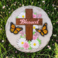 Mellow Monkey Blessed stepping stone featuring a wooden cross, monarch butterflies, and flowers on a round stone base.