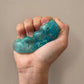 Mellow Monkey Blue Blast Feelzies sensory bracelet being squeezed to show the slow-rebound glittery blue texture.