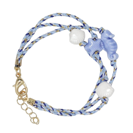 Mellow Monkey blue braided cord bracelet featuring ceramic seahorse, starfish, and seashell charms with gold clasp.