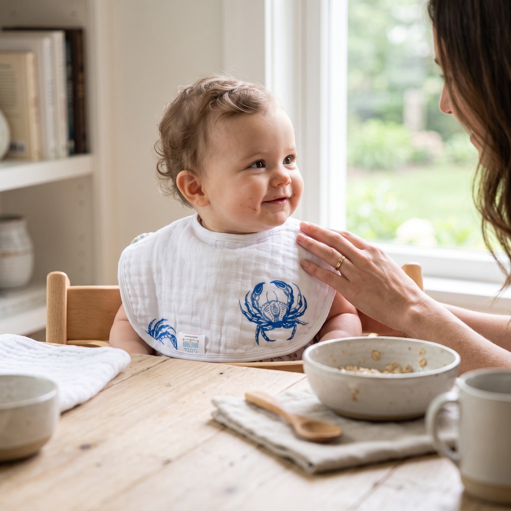 Mellow Monkey 2-in-1 baby bib and burp cloth featuring a blue crab print on soft white bamboo-cotton muslin fabric