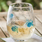 Mellow Monkey stemless wine glass featuring hand-blown clear glass with decorative blue fish and bubble accents.