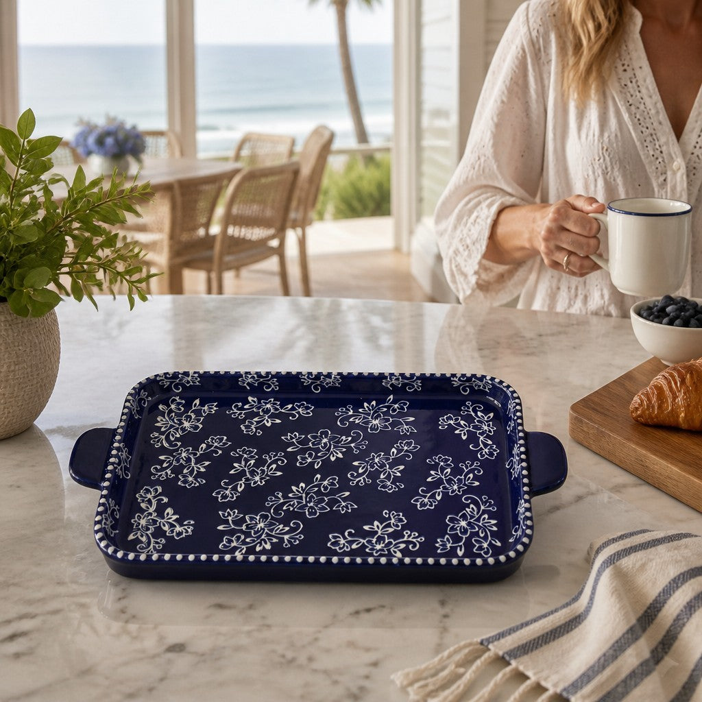 Mellow Monkey Temp-tations blue stoneware serving platter with white floral lace pattern on a marble kitchen counter