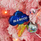 Mellow Monkey deep blue glass cloud ornament with a gold lightning bolt and In A Mood text on a pink Christmas tree.