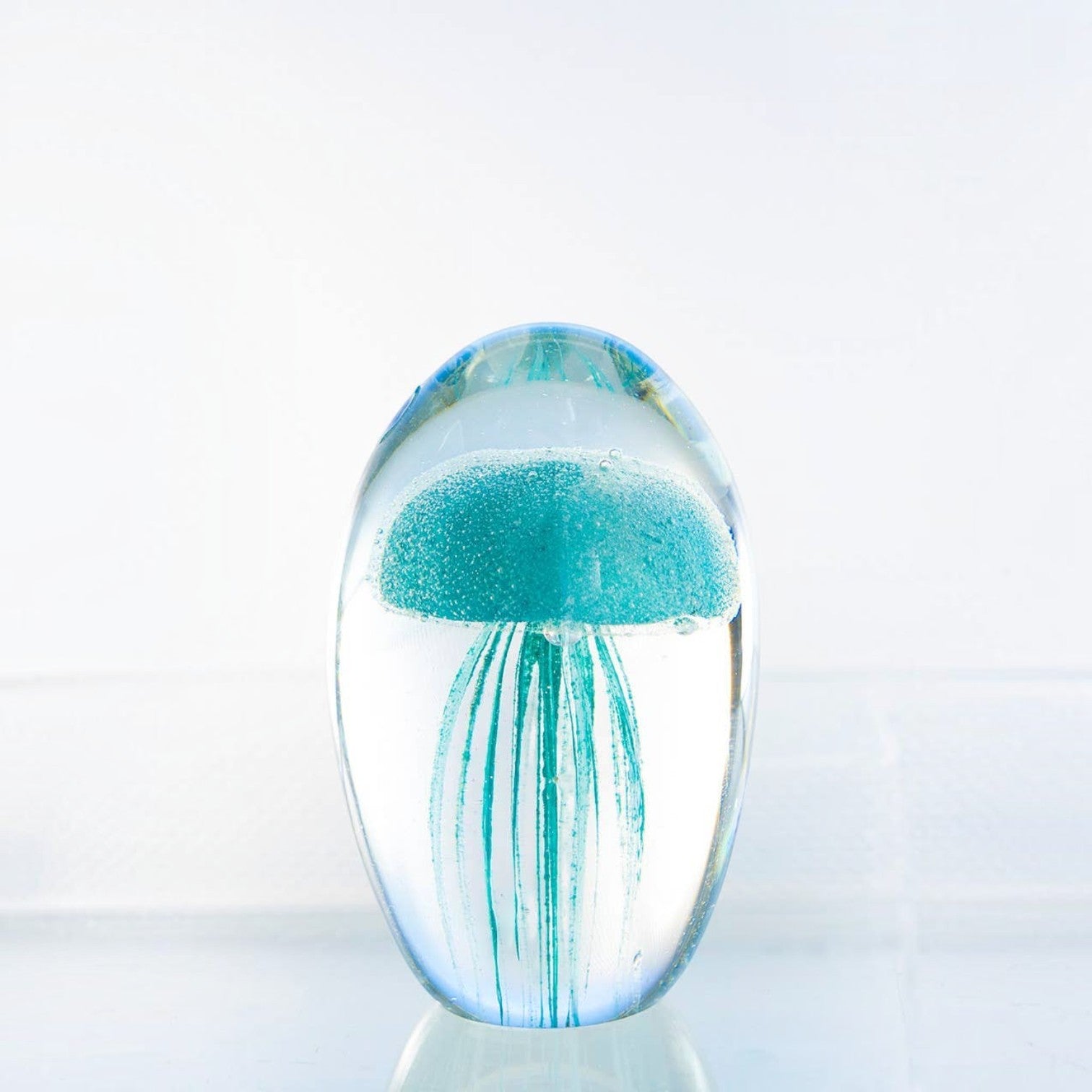 Mellow Monkey blue glass jellyfish paperweight with detailed tentacles inside a clear rounded glass dome
