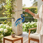 Mellow Monkey blue heron wind chime with sandblasted glass and metal, hanging on a patio for garden decor.