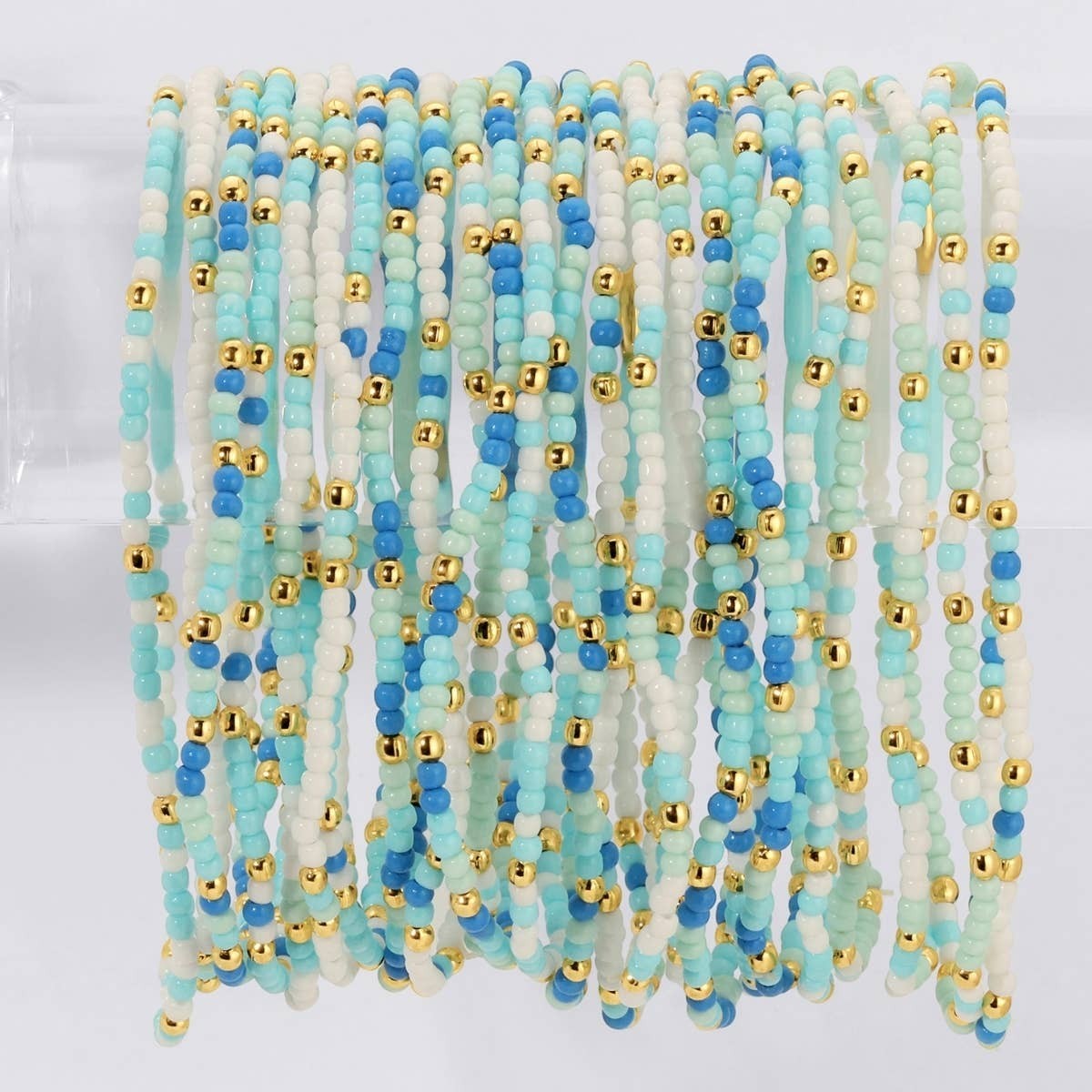 Mellow Monkey stretch seed bead bracelets in blue, mint, and white with 18k gold-plated brass accents.