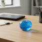 Mellow Monkey blue raspberry SlowFlow squishy apple fidget toy on a wooden office desk.