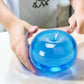 Mellow Monkey blue raspberry SlowFlow squishy apple fidget toy being squeezed by hands on a white desk
