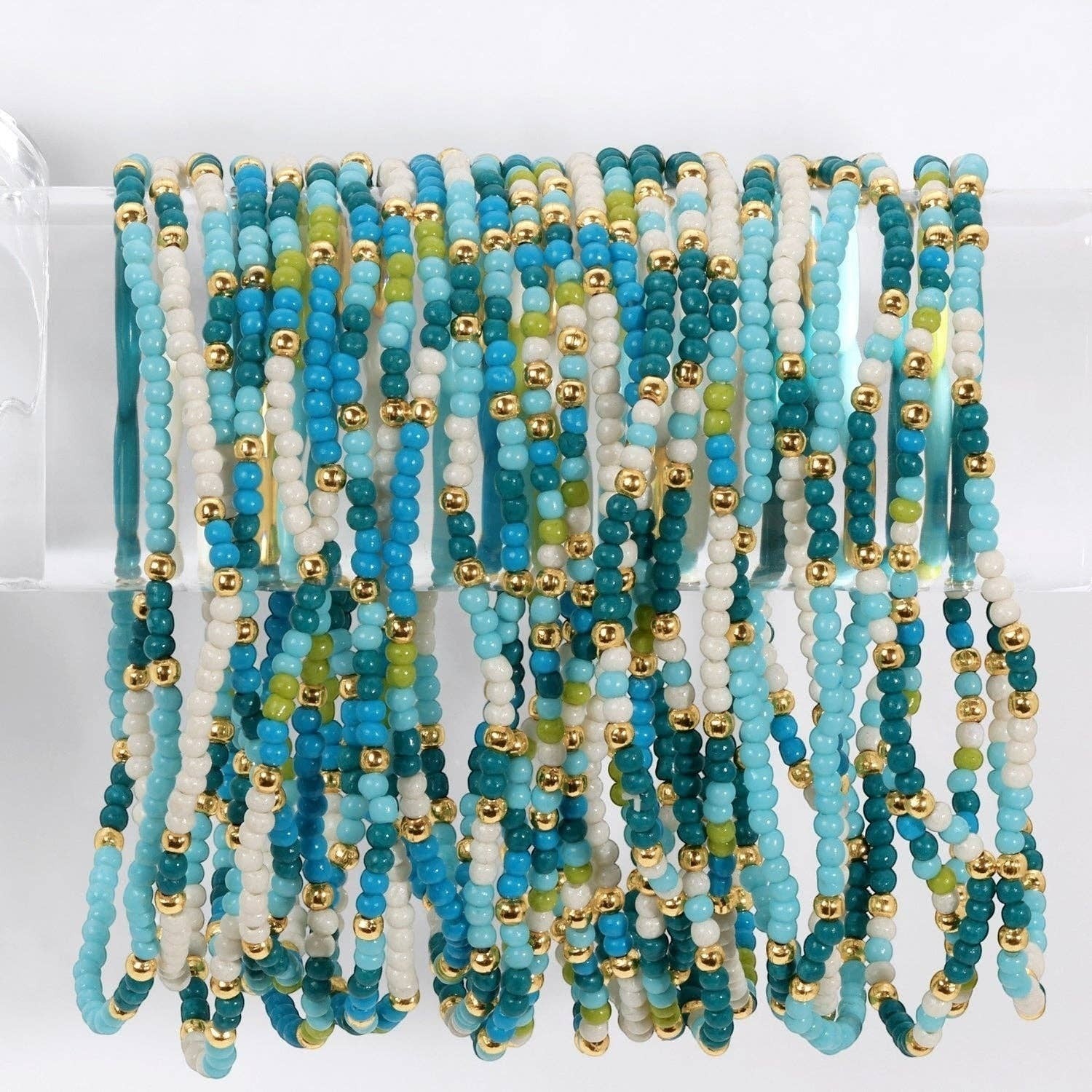 Mellow Monkey stretch seed bead bracelets in blue, white, and green with 18k gold-plated brass accents.