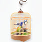 Mellow Monkey motion-activated blue and white singing bird in a hanging cage with realistic perch and greenery