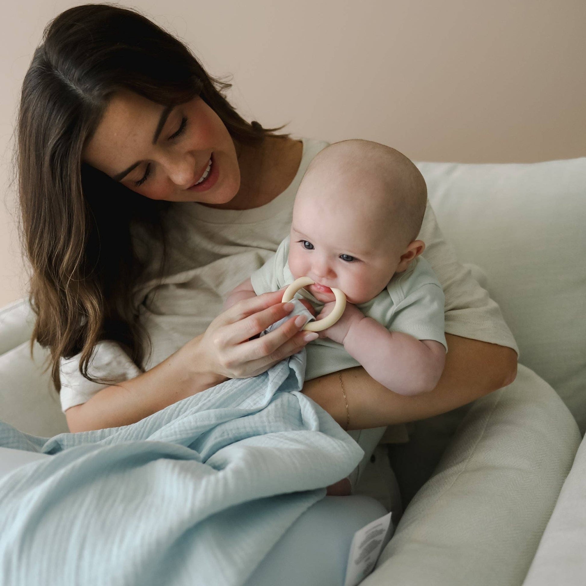 Mellow Monkey Bluebell nursing cover in light blue organic cotton muslin with a built-in silicone teether for baby