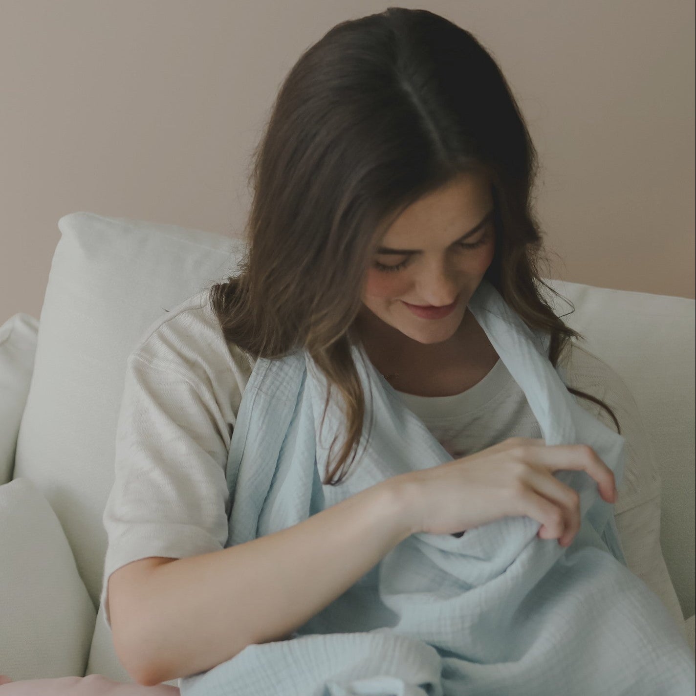 Mellow Monkey Bluebell nursing cover in light blue organic cotton muslin with built-in teether used by a mother