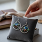 Mellow Monkey Silver Forest bluebird and acorn teardrop earrings with enamel details held on a grey velvet cushion