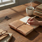 Mellow Monkey blush leather journal with Audrey Hepburn quote. Features unlined acid-free pages and a wrap-around closure.