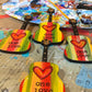 Mellow Monkey hand-painted wooden guitar ornaments featuring One Love text, red hearts, and Rasta-inspired stripes.