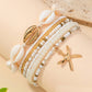 Mellow Monkey bohemian beach bracelet set featuring white beads, seashell accents, and a gold starfish charm.