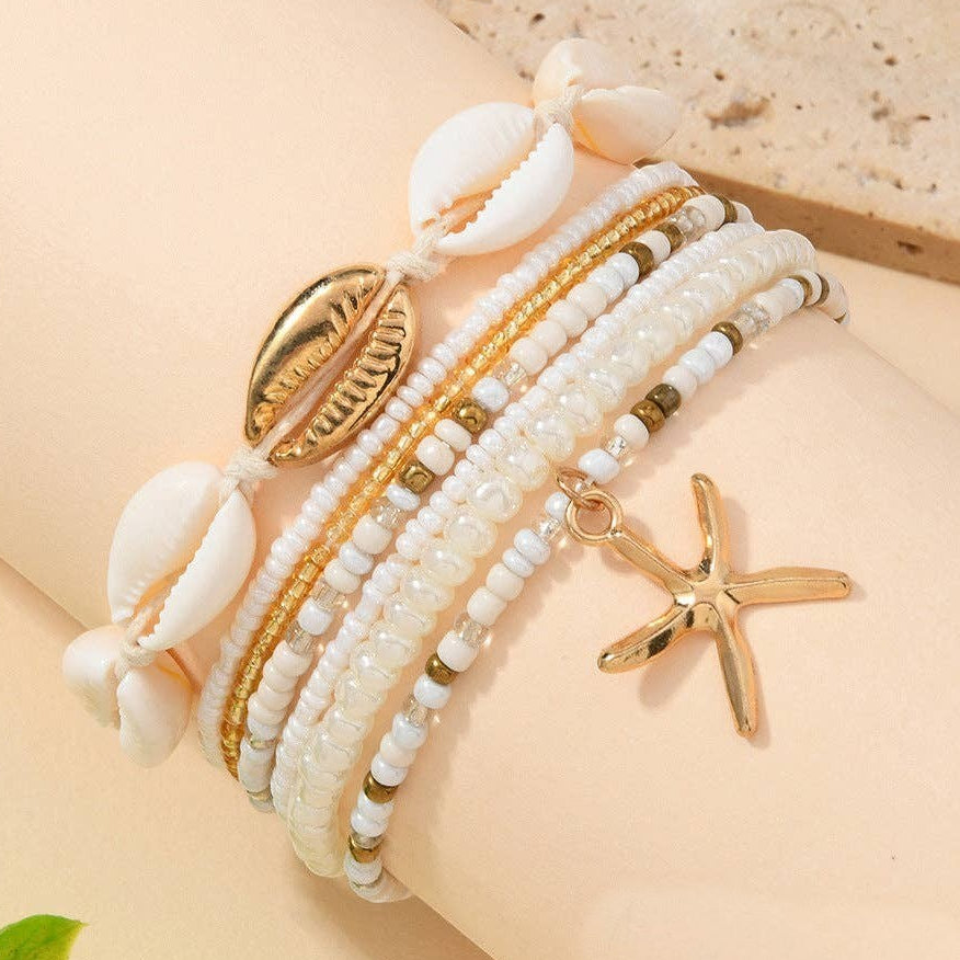 Mellow Monkey bohemian beach bracelet set featuring white beads, seashell accents, and a gold starfish charm.