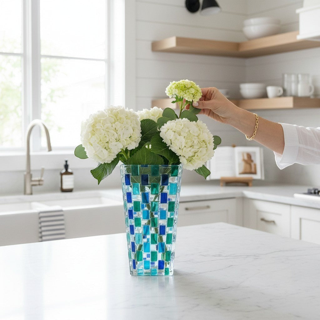 Mellow Monkey Bossanova Aqua Venetian Crystal Vase - 8" hand-painted mosaic glass with blue and green squares, holding white hydrangeas.