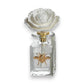 Mellow Monkey Apothecary Guild Botanical Oasis diffuser with white flower top and gold bee accent. Black Fig Vetiver scent.