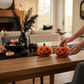 Mellow Monkey boucle fabric jack-o-lantern figurines in orange and black displayed on a rustic dining table