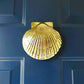 Mellow Monkey handcrafted solid brass scallop shell door knocker mounted on a dark blue door