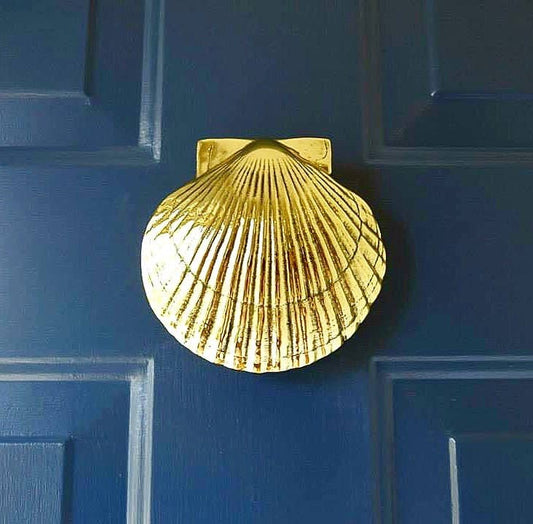 Mellow Monkey handcrafted solid brass scallop shell door knocker mounted on a dark blue door