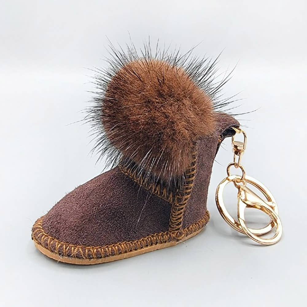 Mellow Monkey brown suede-like boot keychain with fluffy pom-pom accent and gold hardware.
