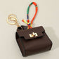 Mellow Monkey brown faux leather mini handbag keychain with colorful scarf accent and gold clasp.