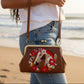 Mellow Monkey brown vinyl kisslock bag with horse and floral wreath embroidery, worn as a crossbody on a beach.