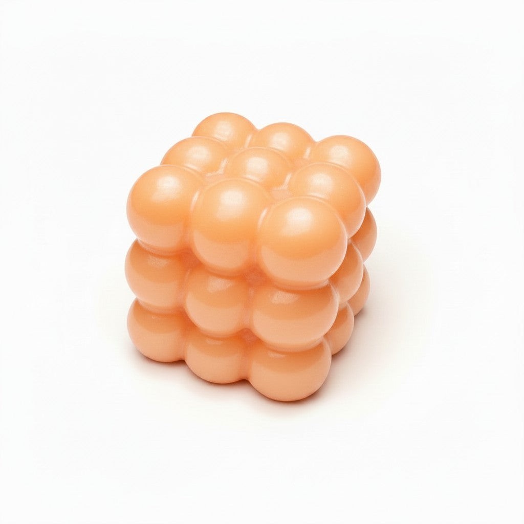 Mellow Monkey 2-inch peach-colored bubble cube stress relief squeeze ball with a smooth, tactile finish.
