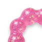 Mellow Monkey Bubblegum Glow Feelzies sensory bracelet in translucent pink with glitter on a marble surface.